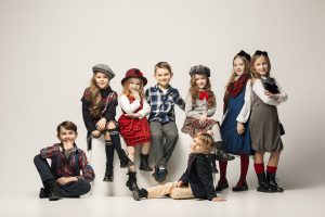 The group of beautiful teen girls and boys on a pastel studio background. Stylish young teen girls posing at studio. Classic autumn style. Teen and kids fashion concept. children's fasion concept