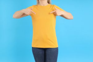 Woman in blank orange t-shirt on blue background